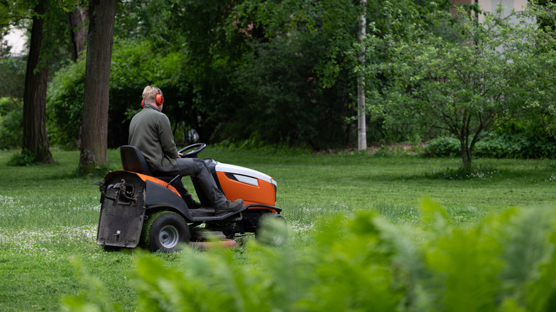 Man cutting grass with riding lawn mower